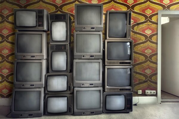 Televisores viejos apilados en la habitación