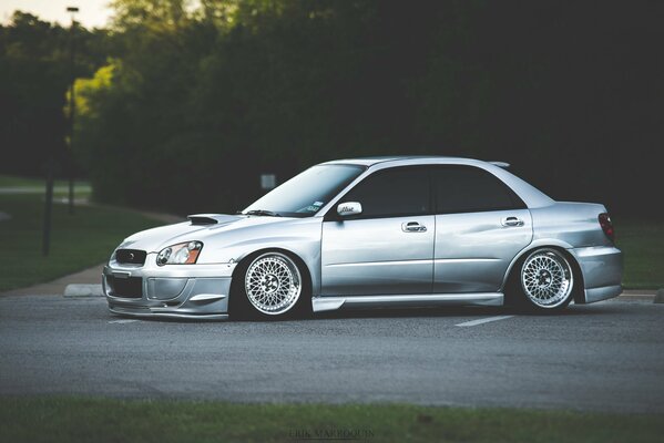 Subaru plateado contra los árboles