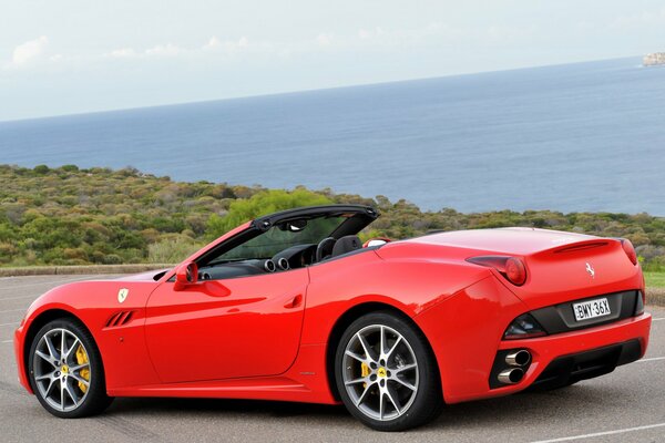 Ferrari rojo California en la costa