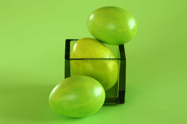Huevos de Pascua verdes en un cubo de vidrio