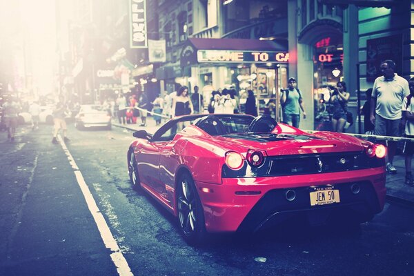 El coche de Ferrari en rojo en la calle de la ciudad
