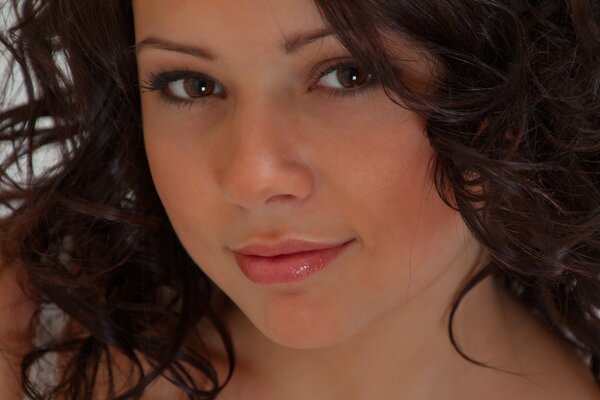 Hermosa chica de ojos marrones con el pelo rizado