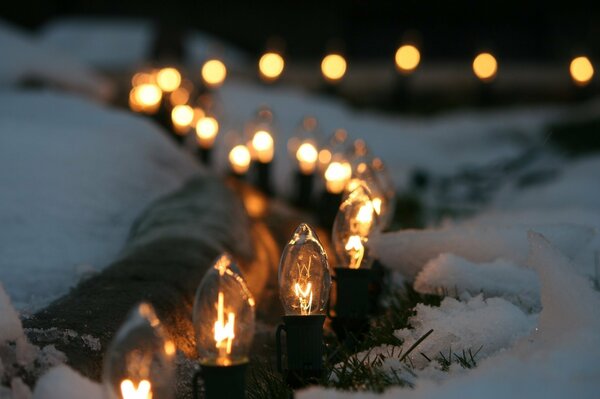 Cadena de bombillas en la nieve blanca