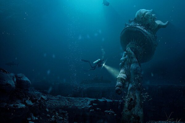 Un buceador estudia el océano. Estatua en el fondo del mar