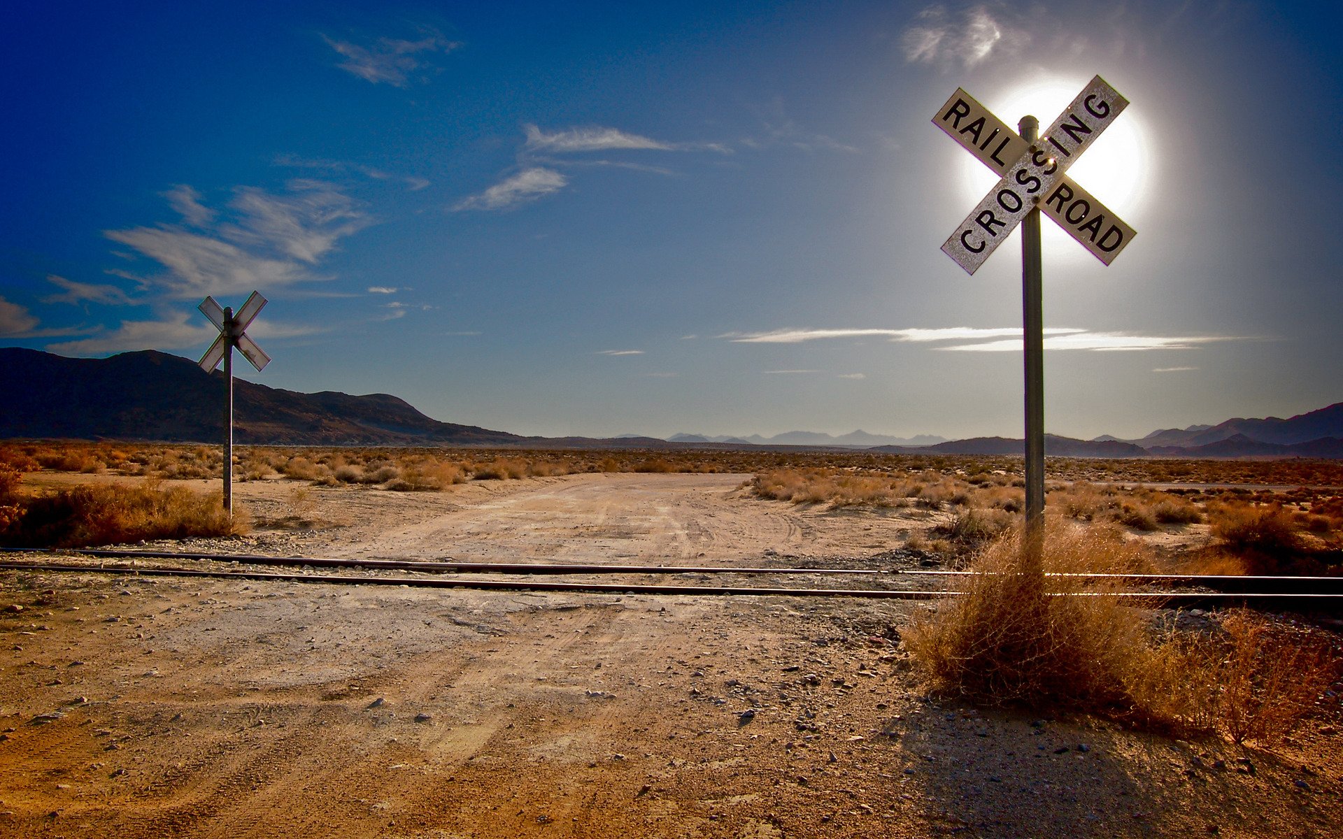 paisaje hierba desierto desiertos ferrocarril ferrocarril rieles durmientes sol montañas nubes nube carretera carreteras intersecciones