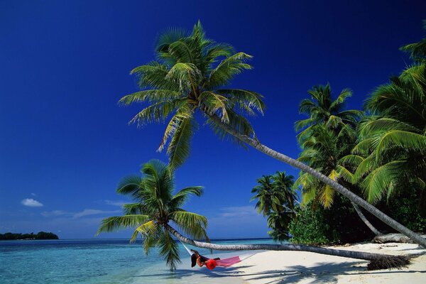 Chica en rojo yace en una hamaca