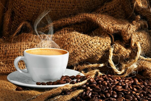 Café humeante en tazas y granos de café