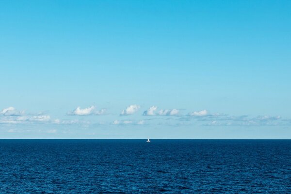 Vela blanca solitaria en la niebla del mar azul