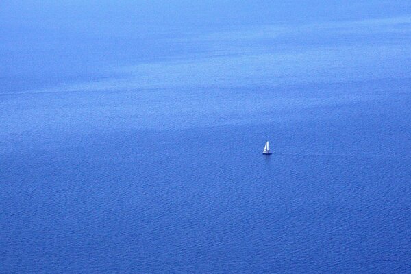 Un solitario velero en el mar azul