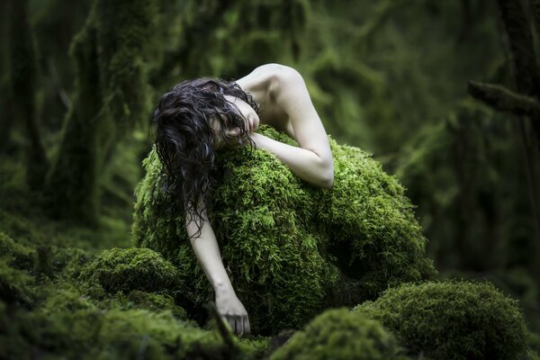 Pálida chica en el bosque en el musgo