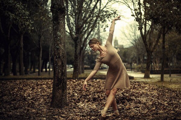 Chica bailando en el follaje de otoño