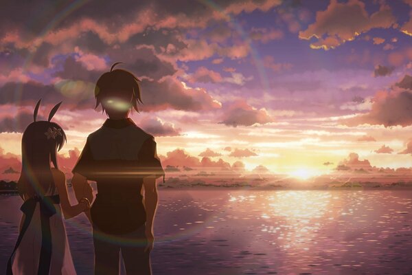 Chico con chica al amanecer junto al mar