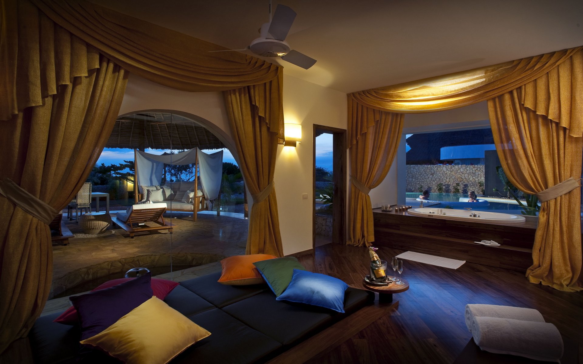interior habitación baño cortinas amarillo almohadas multicolores ventanas grandes champán piscina personas dos en el jacuzzi noche