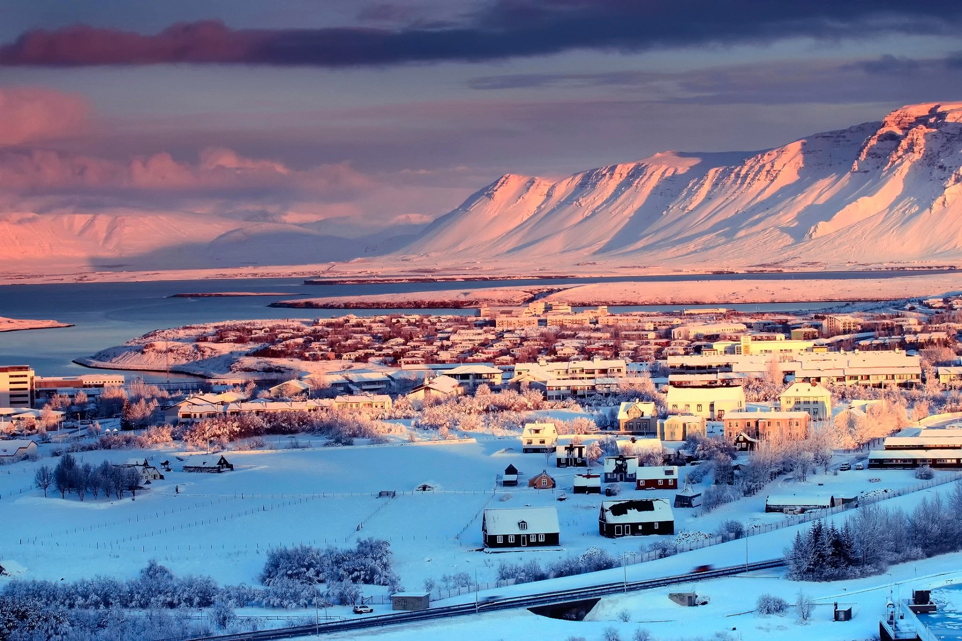 islandia reykjavik ciudad capital casas invierno nieve árboles montañas río cielo nubes
