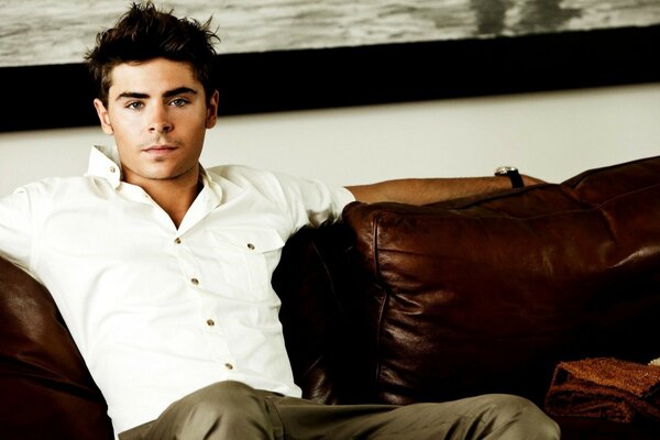 Hombre con camisa blanca sentado en el Sofá