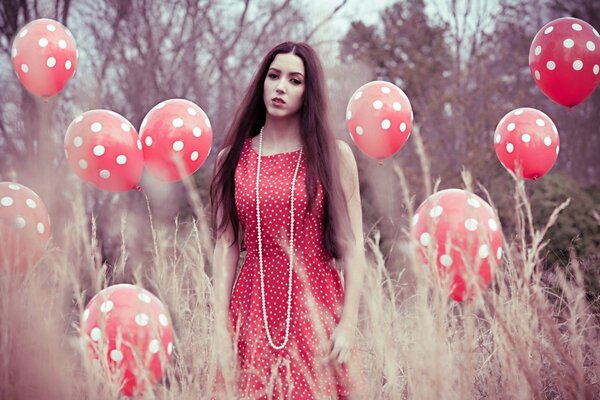 Encantador en un vestido de lunares se encuentra cerca de las mismas bolas