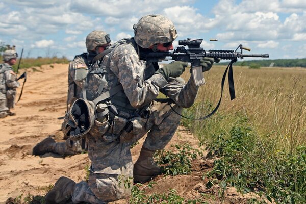 Tres soldados con armas en el campo