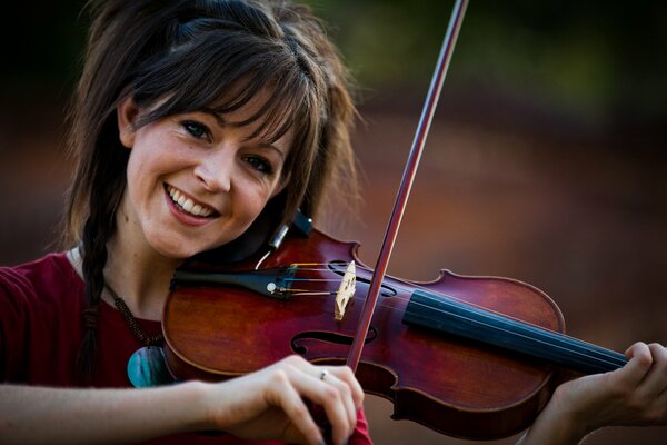 Niña toca el violín y sonríe
