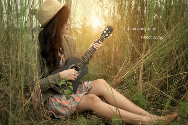 Guitarra en las manos de una chica en la naturaleza