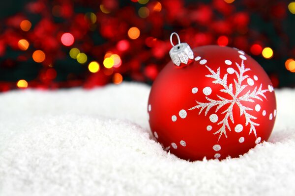 Bola roja de año nuevo en la nieve