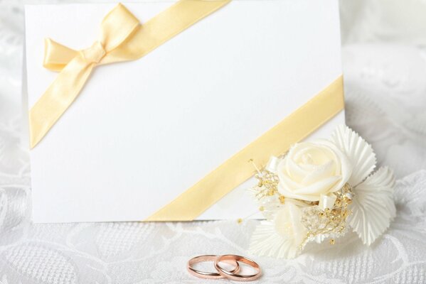 Anillos de boda y tarjeta blanca