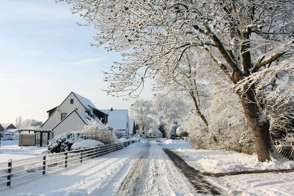 Tranquila calle cubierta de nieve con casas blancas