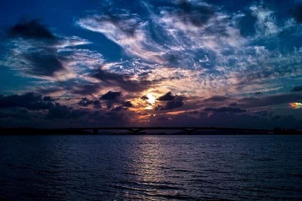 La Luna a través de las nubes brilla sobre el lago