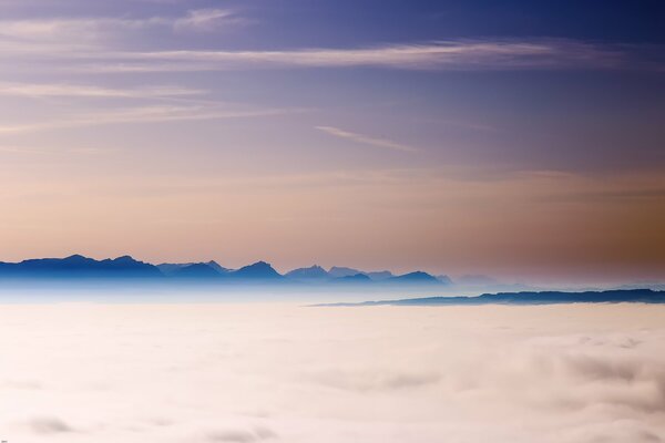 Niebla espesa y las cimas de las montañas alpinas