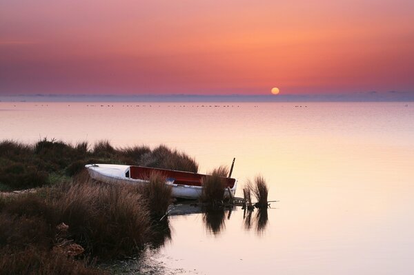 Barco en la orilla al atardecer